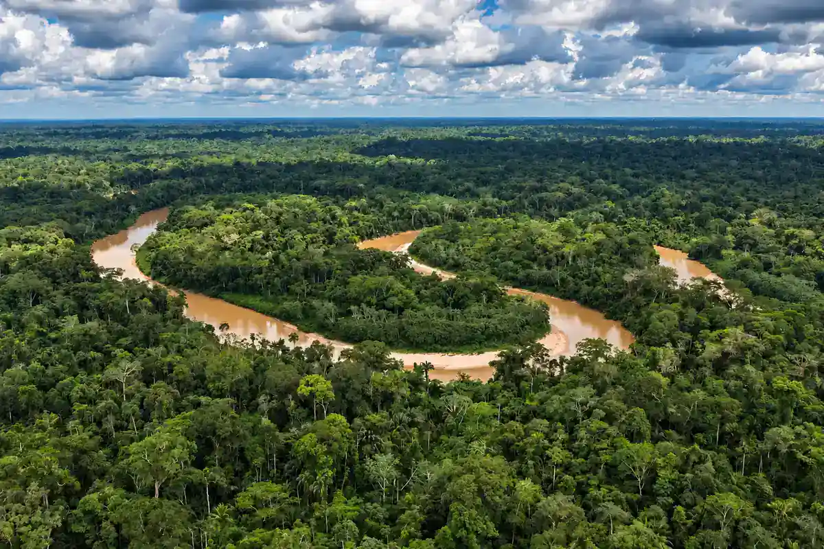 Aerial view of a winding brown river through unbroken Amazon rainforest in Peru