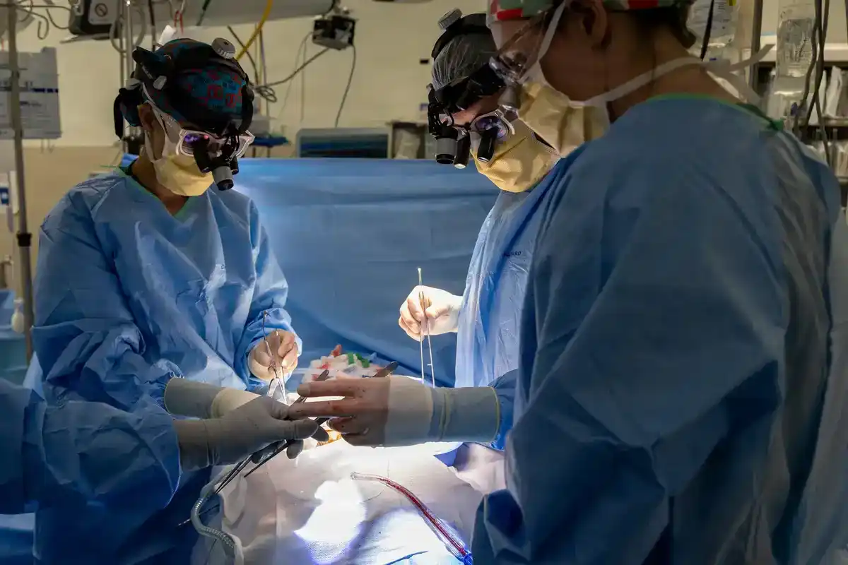 Surgeons wearing magnifying loupes perform a kidney transplant operation at Walter Reed medical center