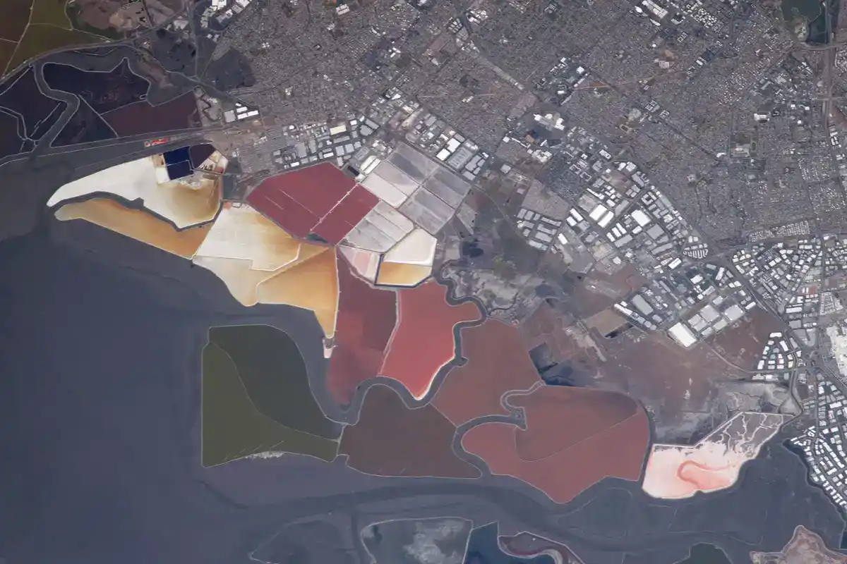 Red, pink, orange, and green salt evaporation ponds at the south end of San Francisco Bay seen from the International Space Station