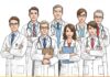 A digitally illustrated group of eight medical professionals, including men and women, standing in a formal pose against a plain white background. They are wearing white lab coats, some with stethoscopes around their necks, while others hold clipboards. The group appears diverse in age and gender, with professional expressions. A yellow-orange banner at the bottom of the image features bold black text that reads TYPES OF DOCTORS.