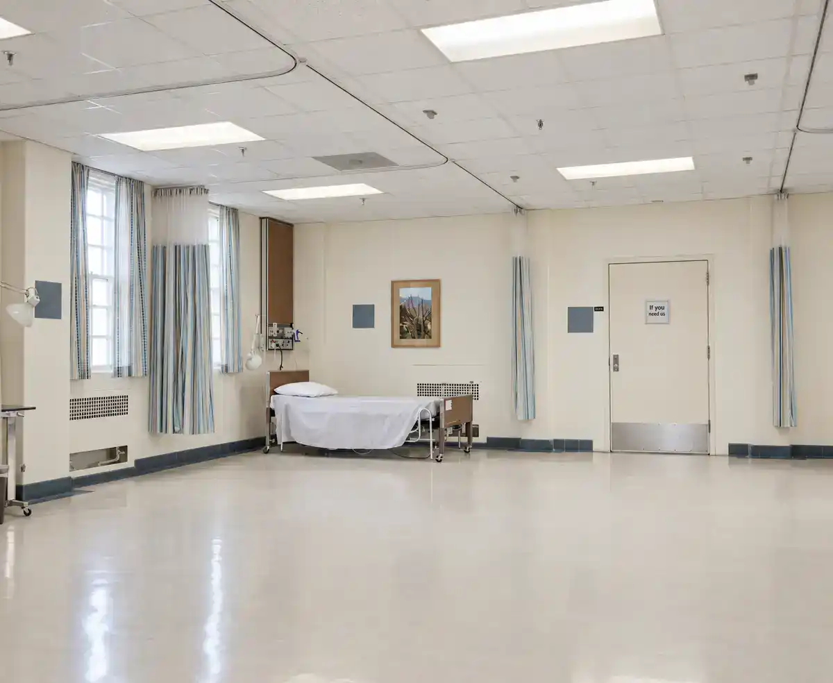 A large Veterans Affairs hospital patient ward with rows of beds and tall windows